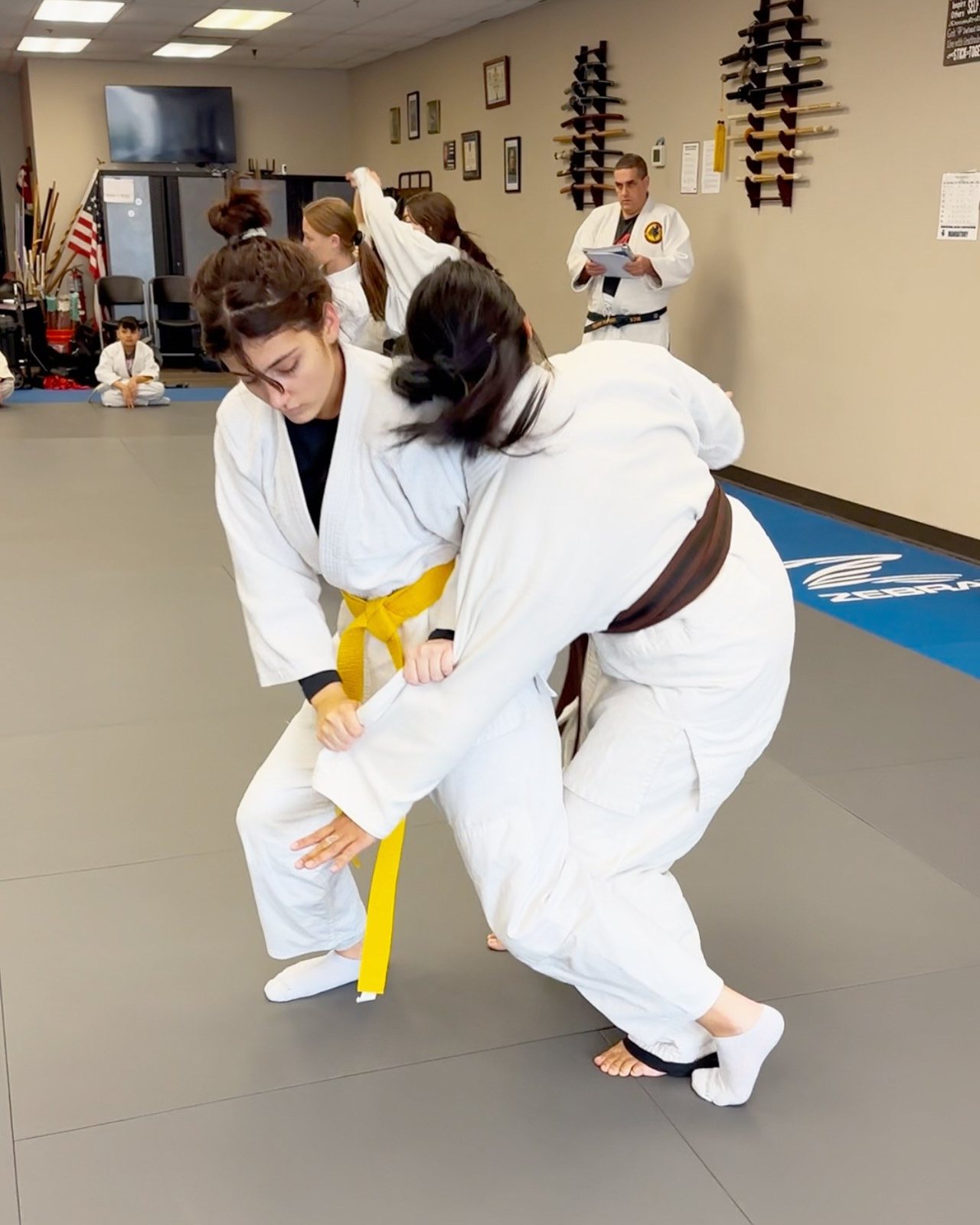 Jujutsu students grappling on the mat at Master Curry